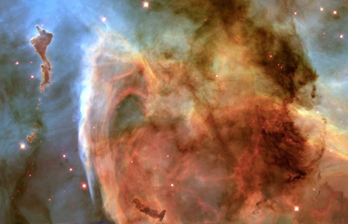 Vibrant cosmic gas and dust clouds display towering, dark sculpted pillars against a swirling backdrop of glowing blues, oranges, and reds, brilliantly illuminated by countless distant stars, evoking the profound mystery of the universe.