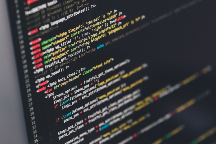 Vibrant lines of programming code on a dark computer screen represent the intricate digital infrastructure of secure blockchain-based credentials.