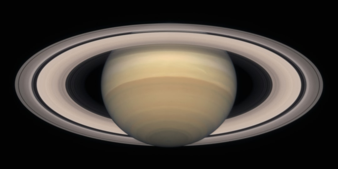 Majestic Saturn, with its distinct yellow-brown banded atmosphere and prominent, layered rings, is beautifully suspended against the dark expanse of space as observed by the Cassini-Huygens mission.