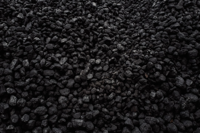 A dense expanse of rough, black coal pieces, representing vital geological energy resources.