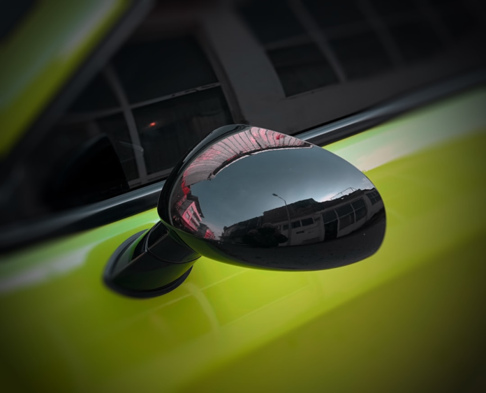 A car's side mirror reflects a warped urban street scene, serving as a visual metaphor for how cognitive biases distort our perception of reality.