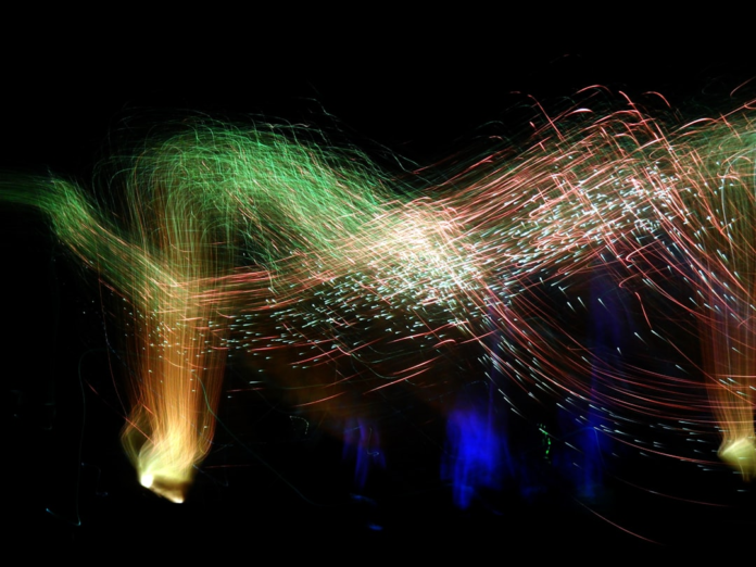 Swirling green and red light trails against a dark void powerfully represent the complex and interconnected forces of disruptive technological innovation reshaping industries.