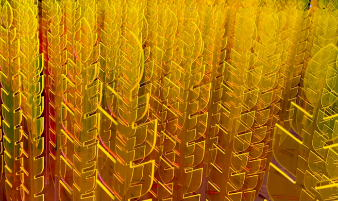 Glowing yellow translucent shapes, resembling stylized leaves or abstract data structures, are densely arranged in vertical rows, evoking future innovation and digital advancement.