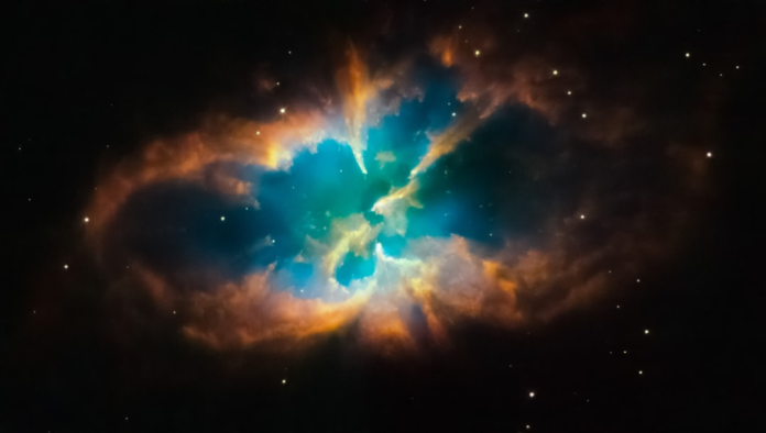 A dynamic cosmic nebula glows with vibrant turquoise and orange gas clouds against a dark star-filled background, evoking the universe's powerful mysteries.