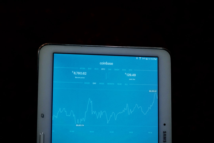 A bright blue screen on a white tablet displays a fluctuating line graph, symbolizing data visualization and the analysis of trends over time against a dark background.