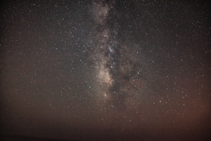 Expansive dark night sky showcasing the luminous band of the Milky Way galaxy stretching across countless stars, inspiring cosmic exploration.
