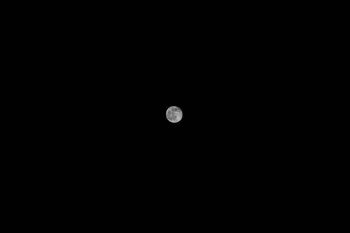 A detailed full moon hangs prominently in the infinite blackness of space, representing the lunar environment central to NASA's VIPER mission for water ice discovery.