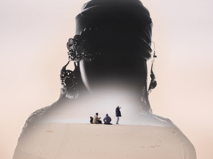 Mysterious double exposure showing the silhouetted head and shoulders of a person wearing a headwrap and elaborate earrings, encompassing a desert landscape with small figures exploring sand dunes, evoking the concept of parallel universes and inner exploration.