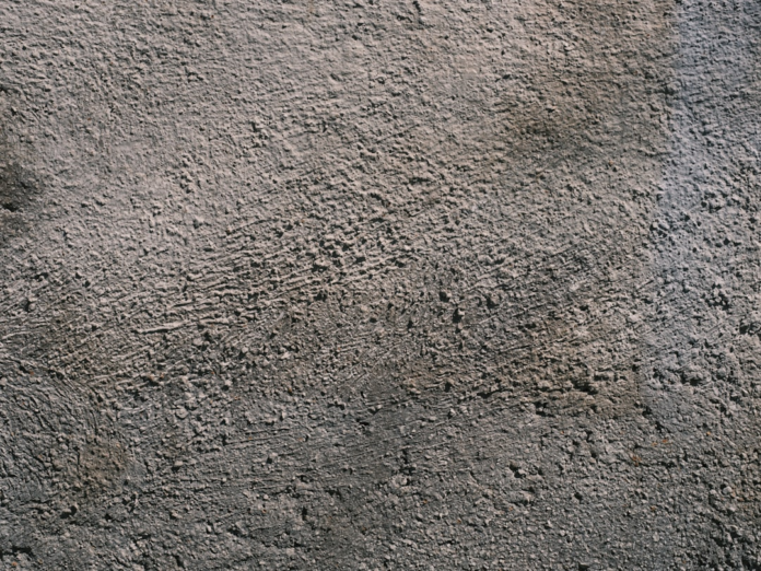 Textured gray rock surface exhibiting coarse grains and natural shadows, symbolizing the rugged nature of deep Earth igneous intrusions.