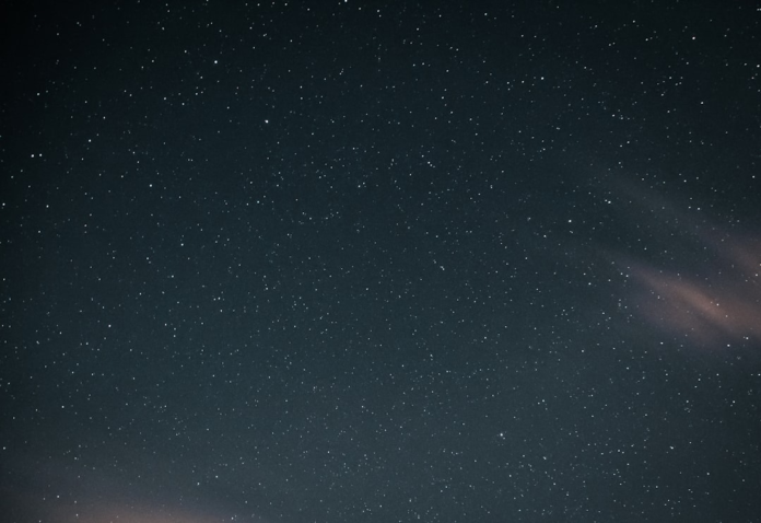 Vast, star-filled night sky, conveying the immense and mysterious expanse where cosmic giants like black holes wander.