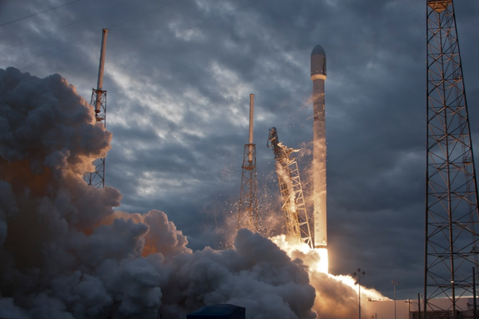 A powerful space rocket lifts off from a launchpad amidst a massive cloud of fiery exhaust and smoke, silhouetted against a dramatic cloudy sky, representing the future of space exploration.