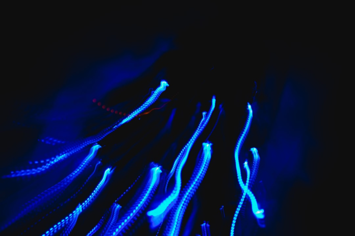 Vibrant blue light streams against a dark backdrop, illustrating the dynamic data flow and decentralized network of Theta Token's video streaming.