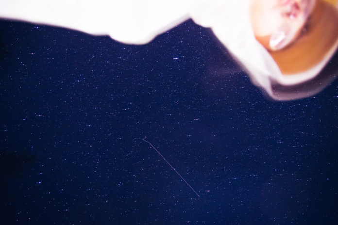Vast, deep blue night sky shimmering with countless stars and a faint diagonal line, inviting contemplation of the cosmos and black holes.